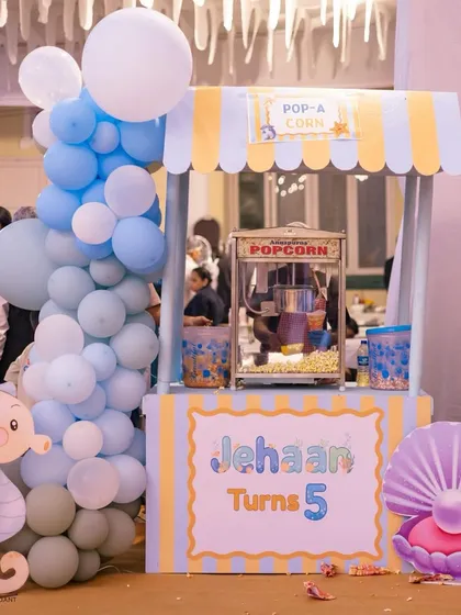 No party is complete without snacks! This adorable 'Pop-A-Corn' stand was custom-made for the event, fitting perfectly with the blue and yellow color scheme of the 'Under the Sea' theme.