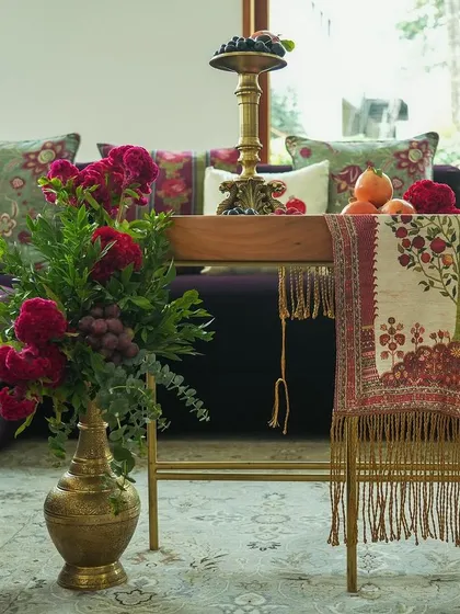 A detail of the indoor seating area. We used a deep purple sofa as a base and brought in the theme through custom-embroidered cushions and a beautifully draped, fringed table runner.