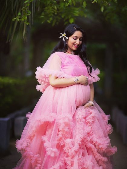 Soft, dreamy, and romantic. This pink ruffled tulle gown is a popular choice for maternity shoots, with layers of fabric that create a beautiful, ethereal silhouette.