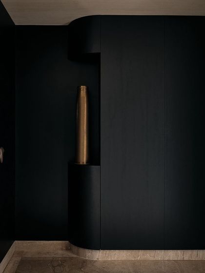 The curved walls in the foyer are designed with a built-in niche, perfect for displaying a single piece of art. This detail adds a layer of sophistication and focus to the space.