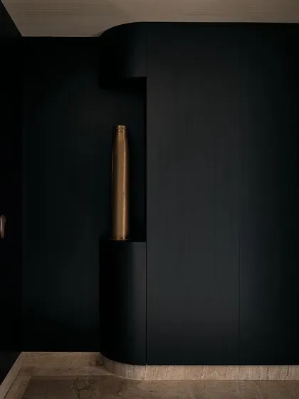 The curved walls in the foyer are designed with a built-in niche, perfect for displaying a single piece of art. This detail adds a layer of sophistication and focus to the space.