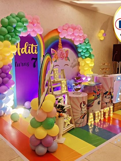 A magical unicorn and rainbow theme for Aditi's 7th birthday. We created a complete fantasy world with a rainbow-striped floor, multiple rainbow arches, unicorn-themed props, and a large light-up number '7'.