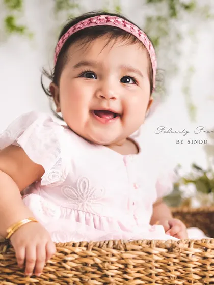 A happy smile from this six-month-old beauty. The simple setup with a basket and flowers allows her joyful personality to be the main focus.