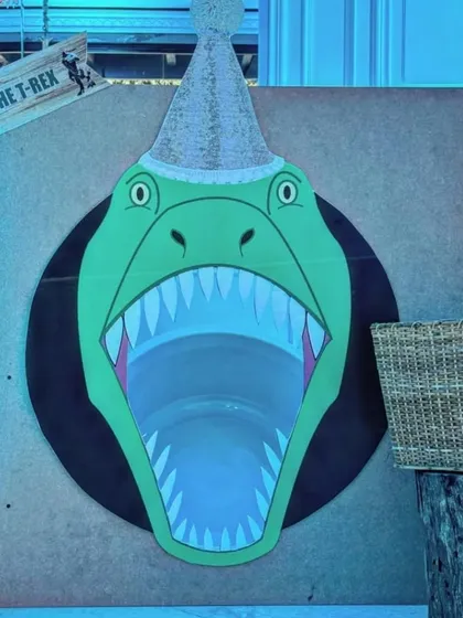 Another fun game from the dinosaur party: "Feed the T-Rex." This bean bag toss game is a hit with kids and is designed with fun, cartoonish graphics to keep it playful and not too scary.