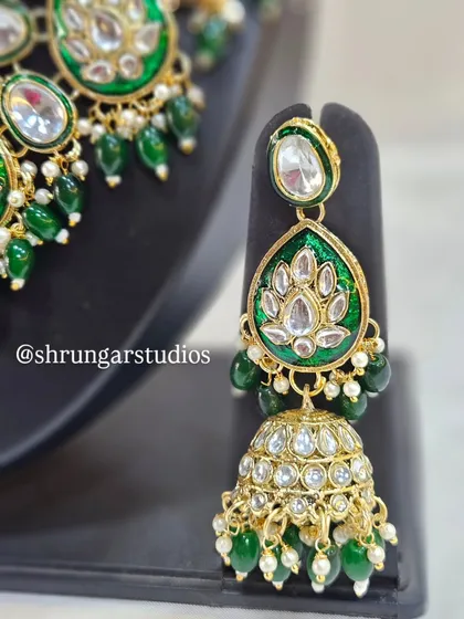 The matching jhumkas with green Meenakari work are just as stunning as the necklace.