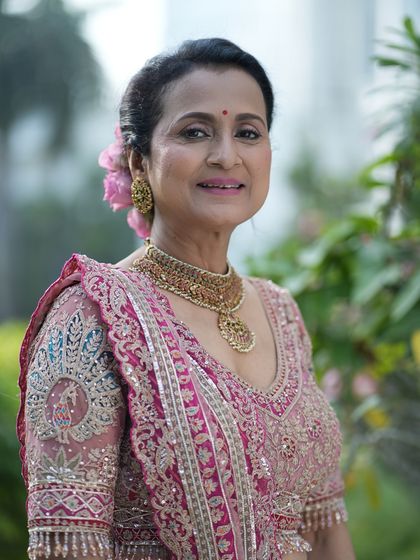 Natural beauty shines in this outdoor portrait. The makeup is subtle and fresh, with a soft pink lip and gently defined eyes that enhance her elegance.