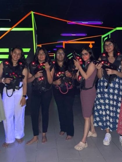 A group of girls ready for a game of laser tag.