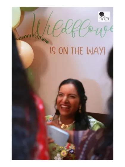 A moment of pure joy and laughter from the mother-to-be, captured candidly during her "Wildflower is on the way" themed baby shower.