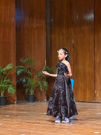 Dressed in an elegant gown, this performer delivers her monologue with grace and emotion.