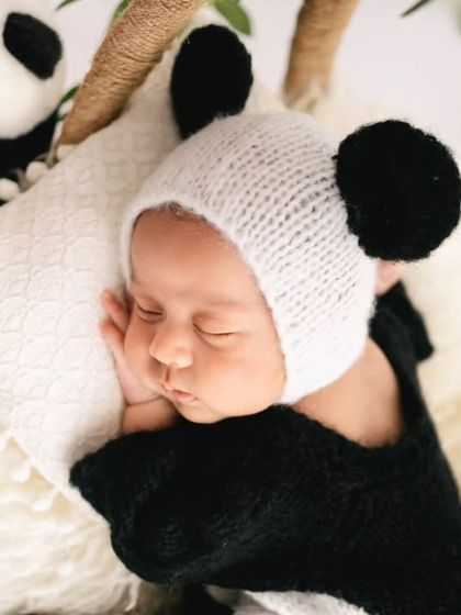 A close-up of our baby panda. The knitted panda hat and soft textures make this an incredibly cute and memorable shot, focusing on the baby's peaceful, sleeping face.