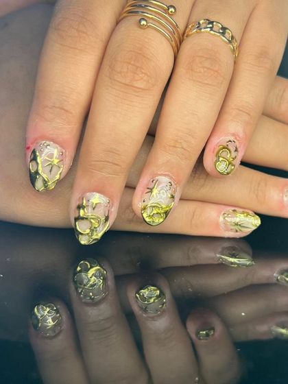 An intricate design with 3D sculpted gold art on a sheer, shimmery base.