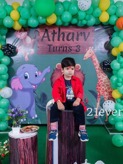 The birthday boy enjoying his jungle-themed setup.