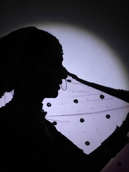 Another take on the bridal silhouette, this time capturing the bride holding her veil. The play of light and shadow creates a dramatic and beautiful image that is both timeless and modern.