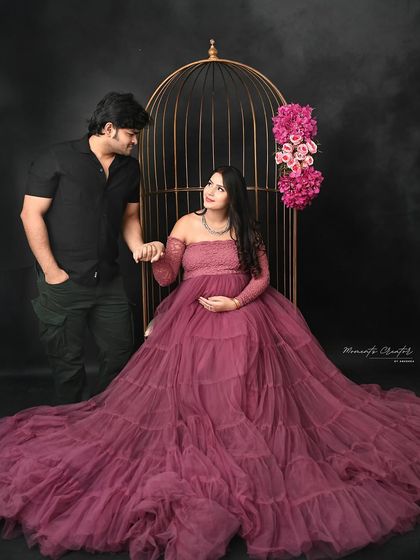 A romantic pose by the golden birdcage. The couple's loving gaze and gentle hold create a fairytale-like atmosphere in this maternity photo.