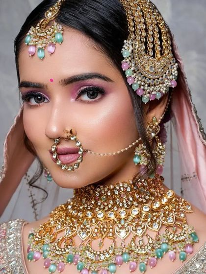 A direct, confident gaze from the bride. The makeup enhances her features with a pop of color on the eyes and a flawless complexion.