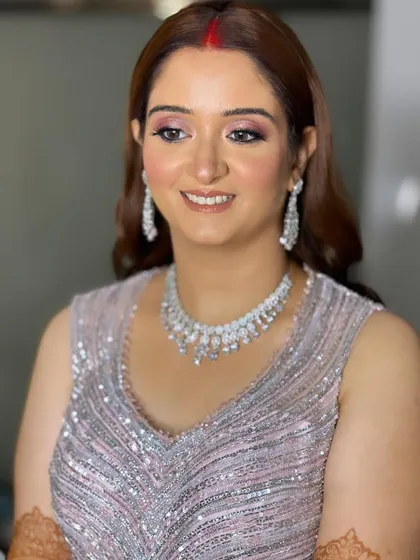 Priyanka's reception look was modern and chic. I created a soft glam look with shimmery pink eyes to complement her silver gown.