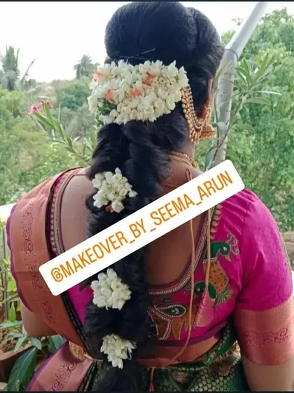 A detailed view of a traditional South Indian bridal braid. This hairstyle features fresh jasmine flowers woven into the plait, a classic choice that adds fragrance and elegance, perfect for weddings and traditional functions.