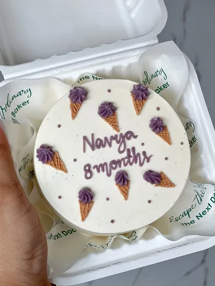An 8-month milestone cake featuring tiny, hand-piped ice cream cones. It's a cute and whimsical design to celebrate another month of sweetness.
