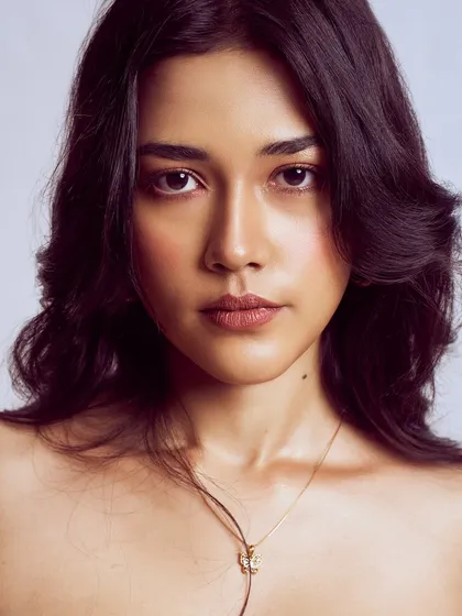 A stunning, simple beauty portrait. The focus is entirely on her flawless skin and beautiful features, enhanced with just a touch of soft, neutral makeup.