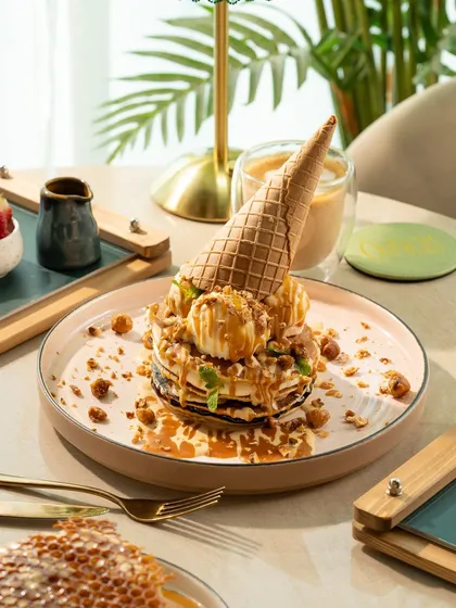 An over-the-top pancake and ice cream creation with a cone on top. This is a fun, maximalist shot perfect for attracting attention on social media.