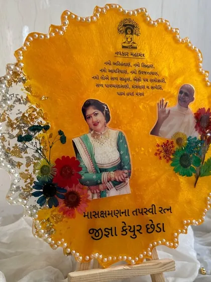 A vibrant yellow frame created for a religious occasion, featuring photos, a mantra, and preserved flowers.