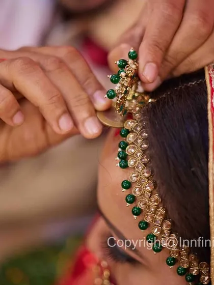 A detail-oriented shot that focuses on a single, significant piece of jewelry. This highlights the traditional elements of the bridal look.