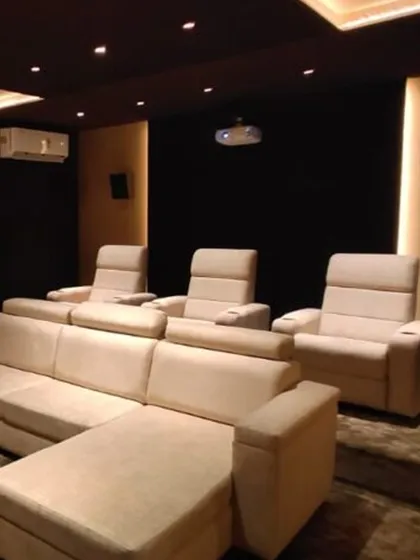 Comfort is key for any cinema experience. This setup combines a plush L-shaped sofa with dedicated recliners, offering flexible seating for the whole family. The two-tier layout ensures everyone has a perfect, unobstructed view of the screen.