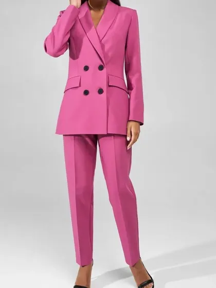 A full-length view of a classic double-breasted power suit in a bold magenta pink, featuring tapered trousers for a sleek, modern silhouette.