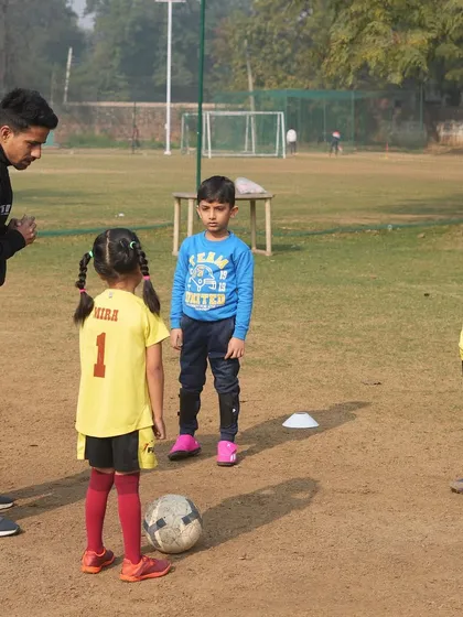 A coach instructing young players. We provide expert coaching that meets international standards, focusing on long-term player growth.