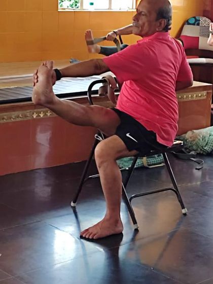 A seated leg stretch using a chair.