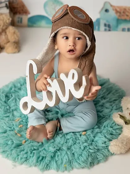A whole lot of love for this one-year-old aviator. Using simple props like this 'Love' sign adds a heartfelt touch to our imaginative and themed photoshoots.