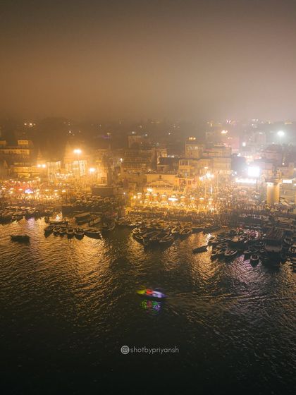 The ghats of Varanasi glowing in the misty night. This drone shot captures the spiritual ambiance of the ancient city as it rests by the holy Ganges.