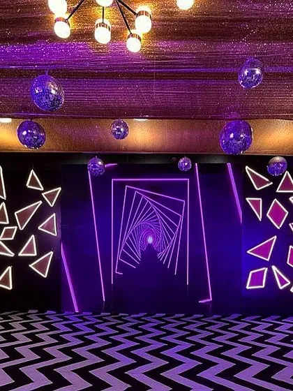 For a futuristic Sangeet, I designed this immersive photo-op area. It features geometric neon light installations and a patterned floor to create a visually striking, high-energy space.