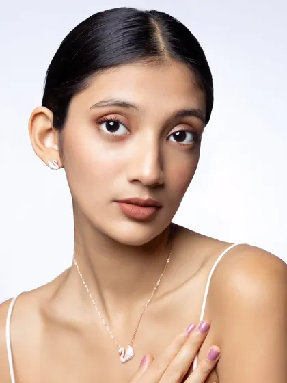 A clean, minimalist shot for Nutan Jewellers. The focus is entirely on the delicate swan pendant, highlighting its simple elegance for a modern jewelry collection.