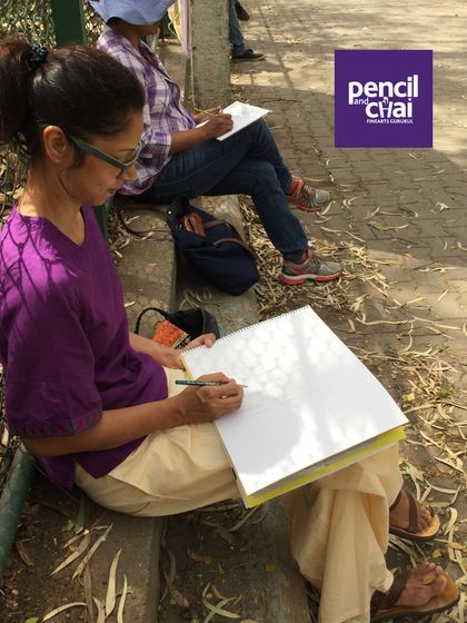 A student finds a spot on a bench to practice her pattern work, surrounded by the sights and sounds of the park.
