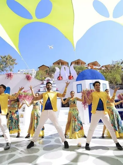 We transformed a venue into a slice of Greece for this 'Around the World' carnival theme. Our team designed the entire experience, from the Santorini-inspired set to the coordinated dancers, making the couple's entry a vibrant, sun-soaked celebration.