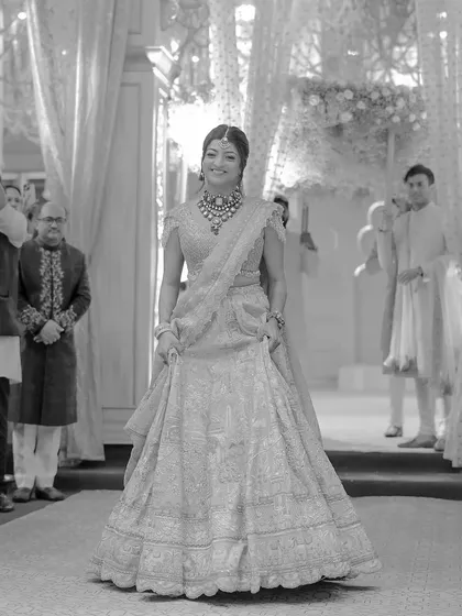 A beautiful black and white portrait of the bride, Tanya, as she makes her entrance. The classic monochrome tones highlight the elegance of her lehenga and her graceful presence.
