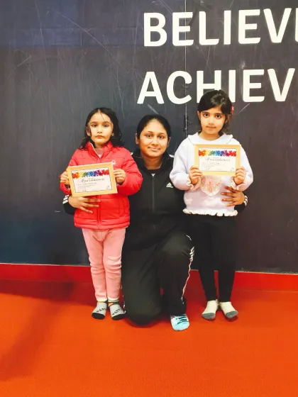 A coach poses with two happy students who have just received their certificates.