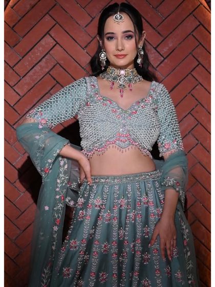 This pastel green lehenga with pink floral embroidery is soft and feminine. The beaded blouse adds a touch of glamour to the delicate design.