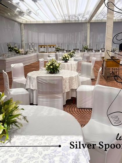 An elegant dining room setup with beautifully arranged tables, each featuring a fresh floral centerpiece. This highlights my ability to manage the entire dining ambiance, not just the food.