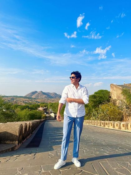 Enjoying a sunny day on a stone bridge. The beautiful landscape and clear blue sky are the perks of being a destination wedding specialist.