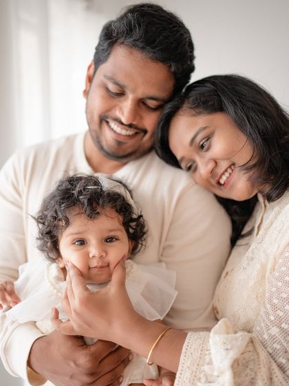 A sweet family portrait, with the mother gently touching her baby's cheek.