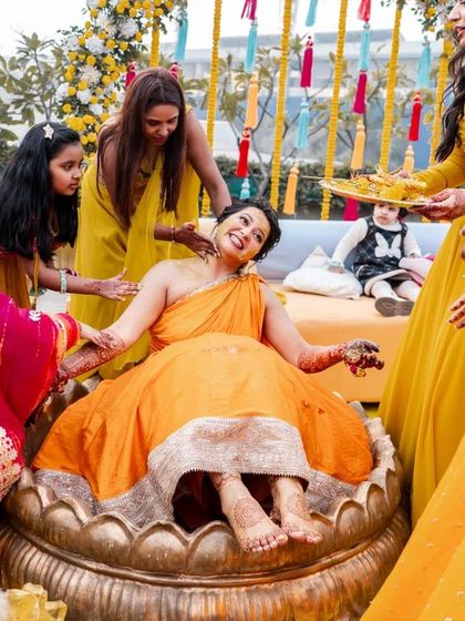 The bride enjoying her Haldi ceremony, surrounded by her bridesmaids in a moment of pure celebration.