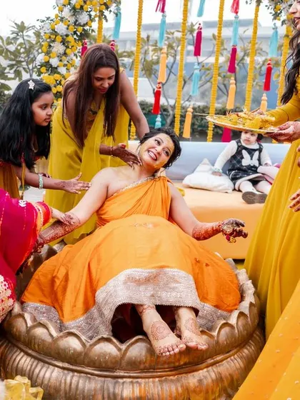 The bride enjoying her Haldi ceremony, surrounded by her bridesmaids in a moment of pure celebration.