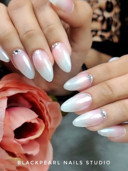 This look combines the soft gradient of baby boomer nails with a pearlescent chrome finish and subtle Swarovski crystal accents. The result is a highly elegant and sophisticated set, perfect for a bride who wants a classic look with a touch of modern shine.