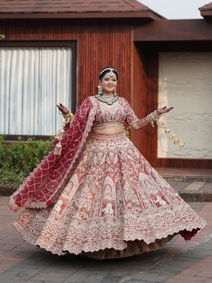 A bride's makeup should complement her entire presence. Here, you can see how our flawless makeup and elegant hairstyle come together with the stunning, heavily embroidered lehenga for a truly breathtaking full bridal look.