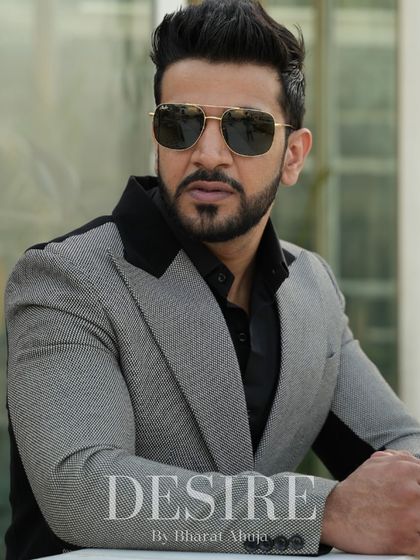 A close-up portrait in the grey and black color-blocked blazer. The black lapels and shoulder panels create a powerful and sophisticated look.