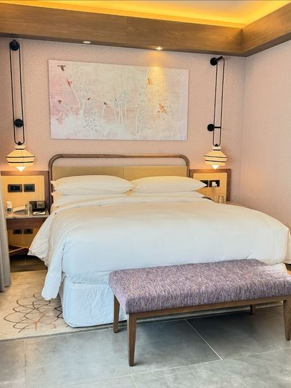 A look at the thoughtful design of our bedroom, featuring a comfortable bed, unique hanging lamps, and art inspired by nature, all contributing to a serene and sophisticated ambiance.