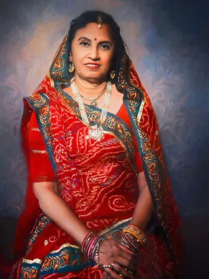 Dressed in a vibrant red bandhani sari, this woman's portrait is rich with color and tradition. The painterly style enhances the intricate details of her attire and the warmth of her smile.
