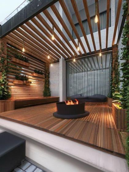 A stunning interior design project where we blended natural elements with architectural elegance. This space features a fire pit, wooden decking, and integrated planters, blurring the line between inside and out.